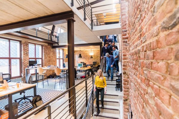 Group of coworkers walking down an open set of metal stairs in a modern office