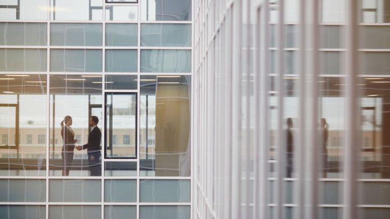 Man and woman shaking hands in a business building